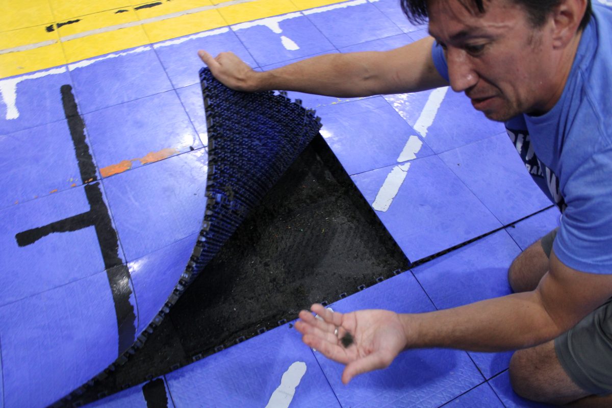 Mr. Lee lifts portion of the gym’s Lego flooring, revealing the wet, black lining.