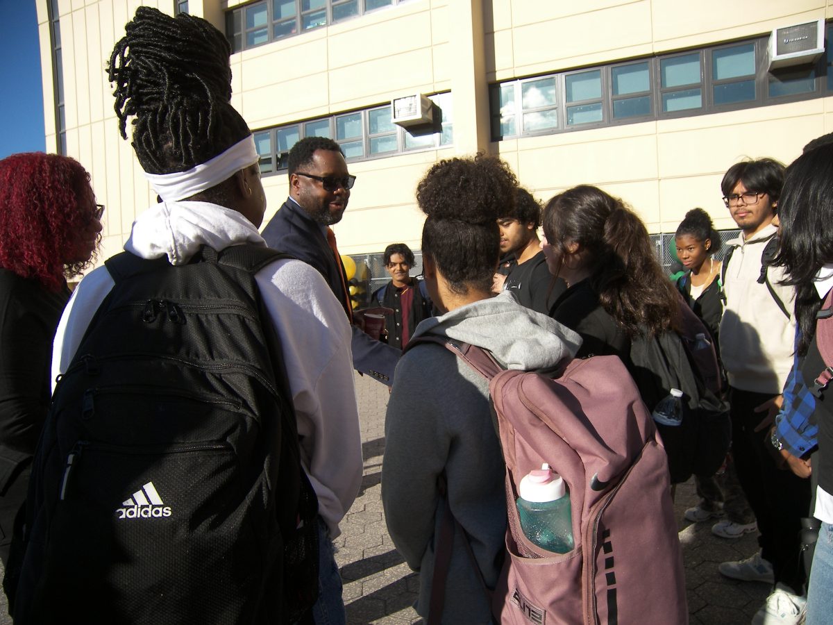 Superintendent Marcel Deans converses with students during a breakfast gathering on the terrace.